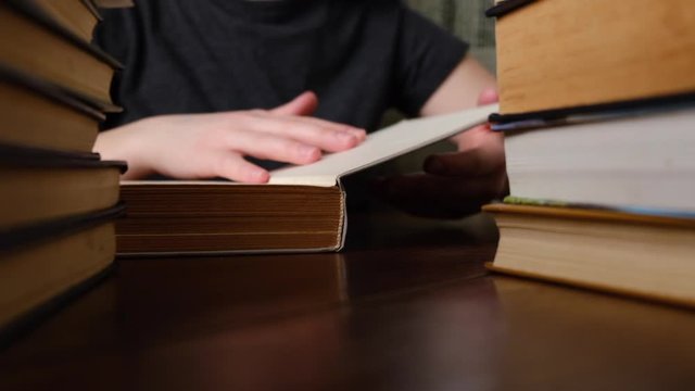 Close up female hands holding old open paper book and moves her fingers along the page while reading, enjoying interesting literature, novel or poetry, teacher working with textbook. Slow motion