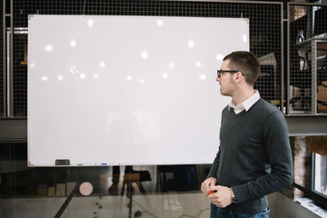 Male lecturer with marker looking at a whiteboard