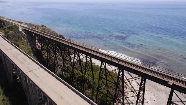 People walk on Santa Barbara coastline bridge, high angle aerial