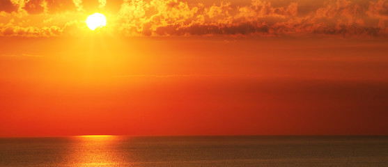 Obraz na płótnie Canvas Bright sunset over the sea. Wide photo.