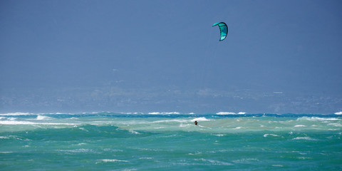 Panoramic view of the ocean with kite surfer on a windy day on Maui island in Hawaii.