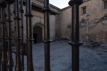 View of the entrance of the collegiate church of La Asunción between the bars of the fence, Pastrana, Guadalajara, Spain