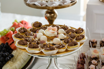 Set of delicious chocolate cupcakes and muffins with white icing. Banquet table for Mothers Day, Valentines Day