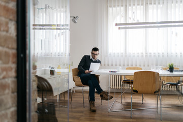 Man sitting in office breakout area and reading