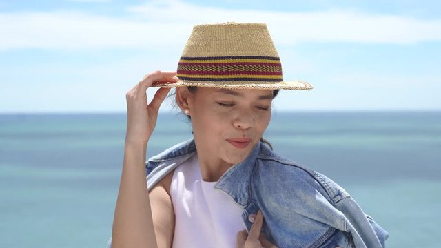 The surfer's young woman is enjoying a straw hat. The background is a blue ocean.