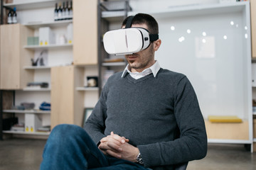 Bearded man wearing virtual reality headset in office environment - Powered by Adobe