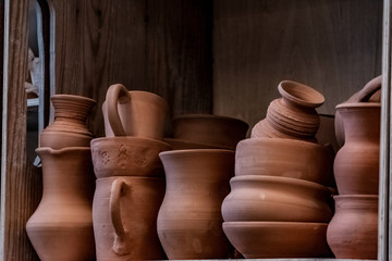 Fototapeta na wymiar a set of ceramic products made of unburned clay standing on a shelf