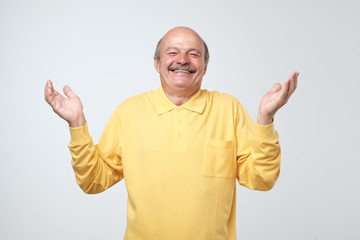 Fototapeta premium Bald senior man smiling on grey background laughing