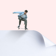 Imagine who's covering white sheet to get digital file icon. Young man, professional scater riding up the edge of huge paper sheet. Digital world, funny imagination of the way the shout appearing.