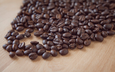Freshly roasted coffee beans in the grinder on the wooden rustic board.