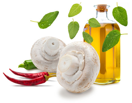 Raw mushrooms, with chilli peppers,  olive oil  and freco oregano leaves (champignon, cut foot, Agaricus Bisporus). Isolated on white background