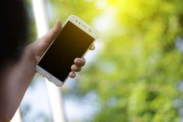 Cropped shot view of woman's hands holding smart phone with blank copy space screen for your text message or information content, female reading text message on cell telephone during in urban setting