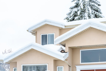 The top of a typical american home in winter. Snow covered roof and nice window.