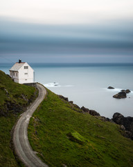 Lane leading to a white country house on the coast. Norway.