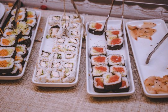 Dishes of rolled sushi on catering table