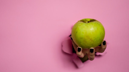 illustration hand breaking with a apple in a pink wall