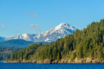 Fantastic view over ocean, snow mountain and rocks at Sechelt inlet in Vancouver, Canada.