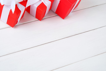 Red gift boxes on a white wooden background with copy space, holiday card