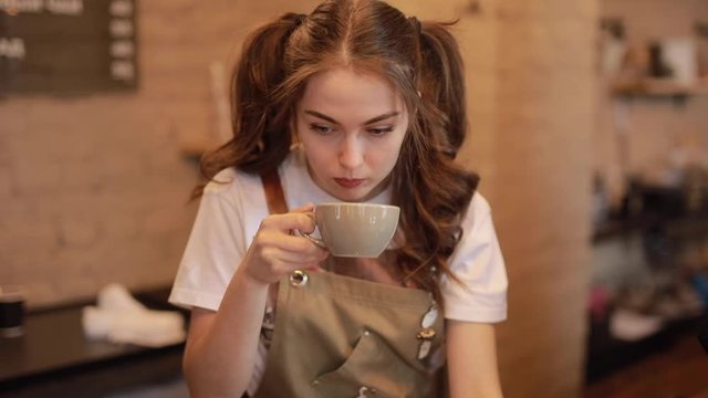 Barista woman testing taste of brewed coffee in the cafeteria