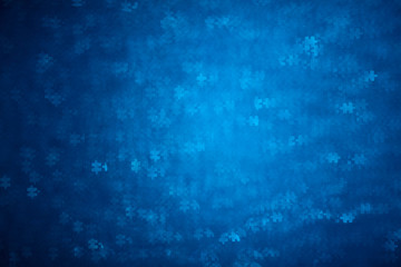 Fototapeta na wymiar Blue Puzzle shape bokeh. Defocused background for autism awareness day. Real photo. Light blue