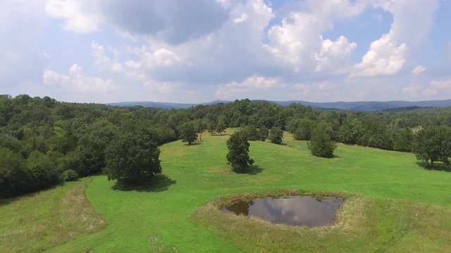 Aerial over a field and pond in the spring