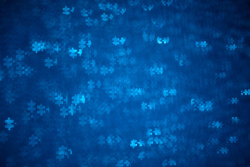 Blue Puzzle shape bokeh. Defocused background for autism awareness day. Real photo. Light blue