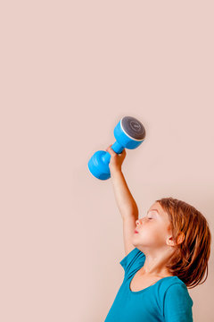 Little cute child girl sportler lifting a dumbbell.  Sport lifestyle, health, power, success concept.