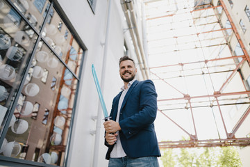 Smiling businessman holding toy sword