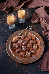  Sweet liqueur,  chocolate candies in cocoa powder  on dark table
