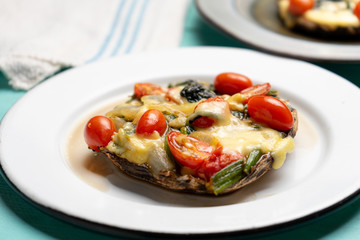 Portobello stuffed with spinach and cheese on turquoise background