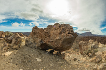 Mountain Teide with white snow spots, partly covered by the clouds. Bright blue sky. Teide National...