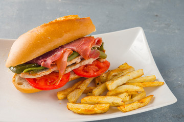 Sandwich Serranito typical in Andalusia with ham, green pepper and grilled pork loin