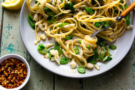 Close up view of plated crab pasta with sugar snap peas and mint