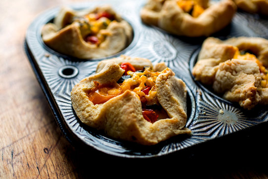 Close up view of baked tartlets with zucchini and tomato