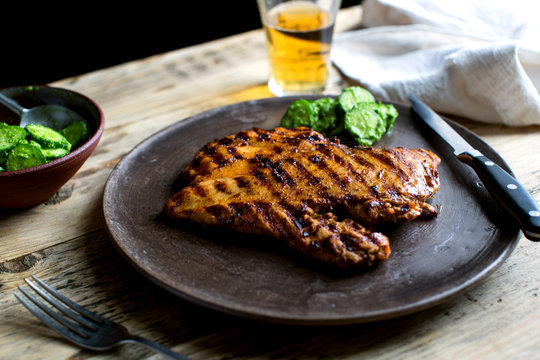 Plated grilled chicken paillard with condiment