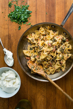 View of pasta with broccoli leaves placed on wooden surface