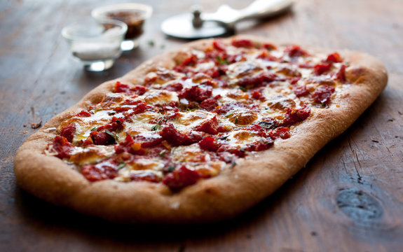 Close up view of focaccia with tomato sauce and green garlic
