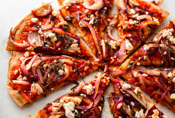 Directly above view of sliced pizza with grilled red onions and feta