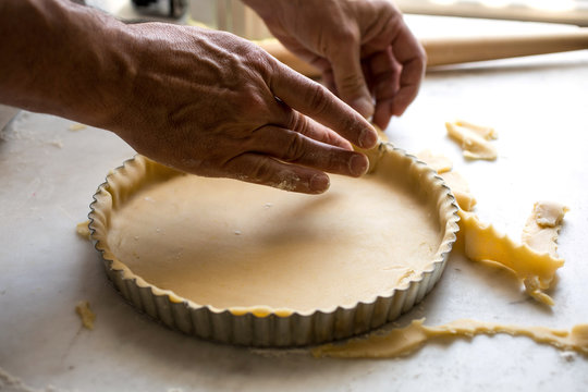 Tilt shift view of rolling out dough into tart pan