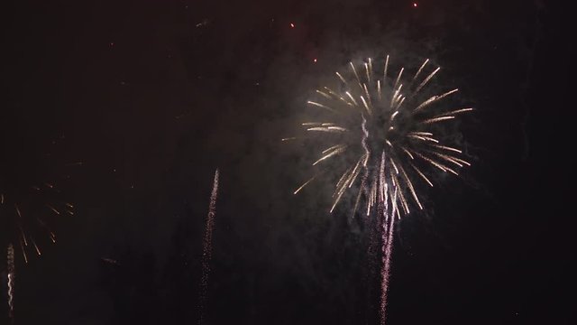 Real fireworks with multicolored rocket explosions in the night sky at new year's eve.