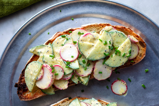 Directly above view of salad topped with cucumber and radish on bread