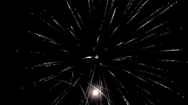Bright colorful fireworks turn to multicolor bokeh lights at holiday dark summer night.
