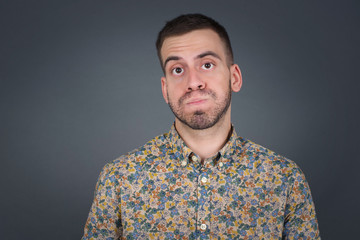 Handsome young man puffing cheeks with funny face. Mouth inflated with air, crazy expression.