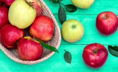 Naklejka na ściany i meble .red and yellow apples in a basket on a green wooden background