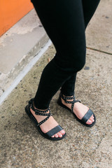 Trendy black studded women's sandals on model
