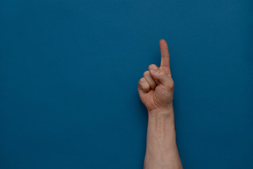 Hand pointing gesture on a blue background