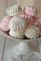 Pink homemade zephyr or marshmallow on plate and lace, vertical image, tenderness concept