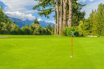 Obraz premium Golf course with gorgeous green and pond.