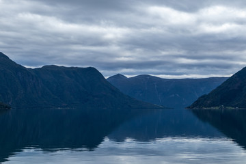 Fototapeta na wymiar Heavy clouds sky with mountains reflection in lake