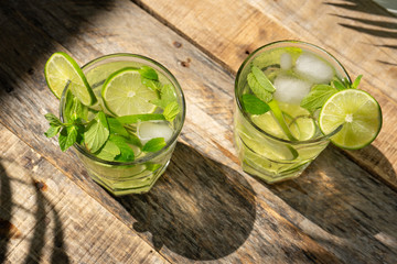 Lime and mint cocktail with rum called "mojito" on wooden background